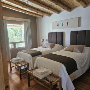 a bedroom with two beds and a window at Cabañas Bodega Kindgard in Purmamarca