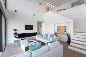 a living room with white furniture and a tv at 4-bed Luxury Villa 5-star Resort in Caldes de Malavella