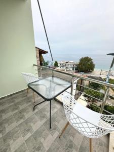 a balcony with a table and chairs and the ocean at Rooms with view in Himare