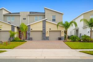 a house with a driveway and palm trees at CONDO 2bed2bath next to Disney w Free Water Park in Kissimmee