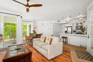 a living room with a couch and a table at Tropical Princeville Condo with Private Lanai in Princeville