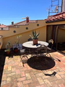 a patio with a table and chairs on a patio at La casa colorata nel cuore della Venezia in Livorno