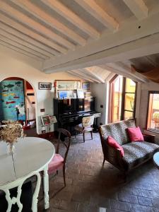 a living room with a table and a piano at La casa colorata nel cuore della Venezia in Livorno