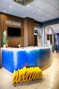 a hotel lobby with a blue counter and yellow chairs at Hotel Madison in Bellaria-Igea Marina +74 photos