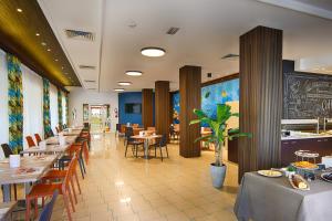 a dining room with tables and chairs and a restaurant at Hotel Madison in Bellaria-Igea Marina