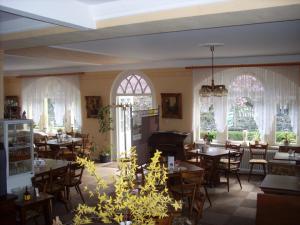 a dining room with tables and chairs and windows at Gästehaus Viktoria in Bad Bertrich