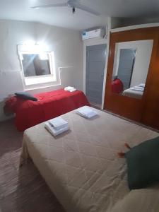 Un dormitorio con una cama roja y un espejo. en Alquileres temporal Belgrano, en Argentina 1 foto más