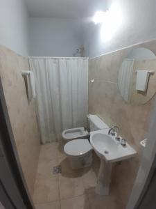 Un baño con inodoro, lavabo y espejo. en Alquileres temporal Belgrano, en Argentina