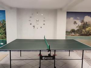 a ping pong table in a room with a clock at Idyllische Ferienwohnung in Walldürn