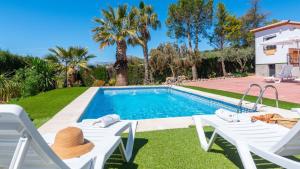 a villa with a swimming pool and two lawn chairs at Cortijo El Púlpito Periana by Ruralidays in Periana