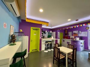a kitchen with purple and green walls and a table and chairs at Himalayan Hostel in Zagreb