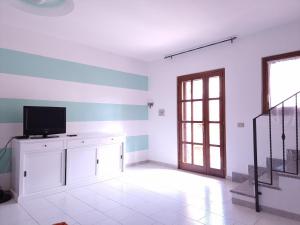a living room with a television and a staircase at Residenza Piras - Budoni Sweet Home in Tanaunella