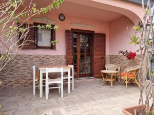 a patio with a table and chairs in front of a house at Residenza Piras - Budoni Sweet Home in Tanaunella