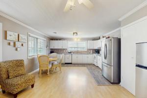 Una cocina con refrigerador y una mesa y sillas. en Waterfront Oasis, en Carolina Beach