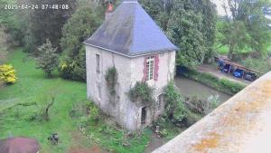 an old building in the grass next to a river at La Tour Des Douves in La Celle-sous-Gouzon +3 photos