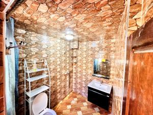 un bagno in pietra con lavandino e WC di Atlas Hostel Taghazout a Taghazout