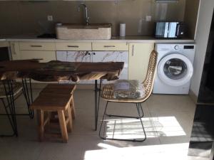 cocina con mesa y lavadora en La Ferme des Chèvres, en La Cadière-dʼAzur