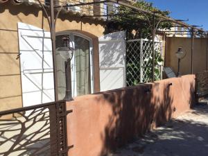 Una farola junto a una pared con una puerta blanca. en La Ferme des Chèvres, en La Cadière-dʼAzur