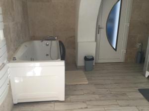 Un baño con bañera blanca y espejo. en La Ferme des Chèvres, en La Cadière-dʼAzur 4 fotos más