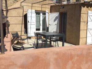 Una mesa y sillas negras en un patio. en La Ferme des Chèvres, en La Cadière-dʼAzur