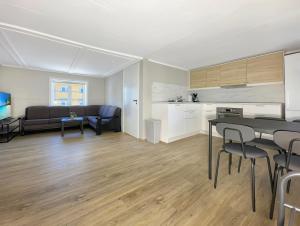 a kitchen and a living room with a table and chairs at Apartment near city centre, free parking in Lillehammer +12 photos