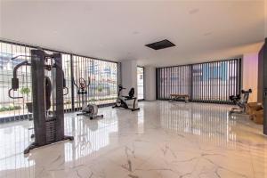 a gym with exercise equipment in a room with large windows at 0017 White Sail Cozy 1-Bedroom Apartment Steps from Yekta Mall in Mahmutlar, Alanya in Alanya