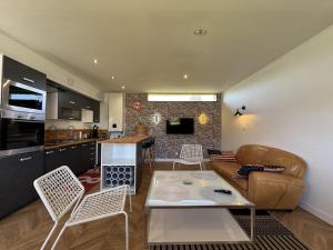 a kitchen and living room with a couch and a table at La Villa DS - 9pers - Piscine - Rêve au Mans in Changé