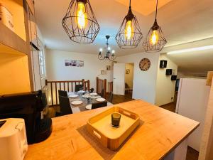 une cuisine et une salle à manger avec une table et des lumières dans l'établissement Le Boudoir, à Carcassonne 10 autres photos