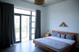 ein Schlafzimmer mit einem Bett und einem großen Fenster in der Unterkunft Moc Nhien homestay in Phước Hậu (1)