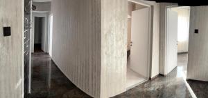 a hallway with white walls and white doors at Alfredo Apartament in Buzau