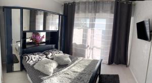 a bedroom with a bed with pillows and a window at Alfredo Apartament in Buzau