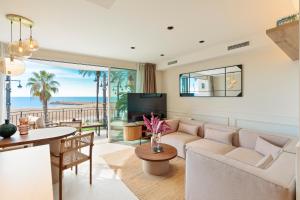a living room with a couch and a table and a television at Sitges Group Ocean in Sitges