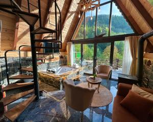 a living room with a staircase and a large window at Waterfall suit bungalov in Çamlıhemşin