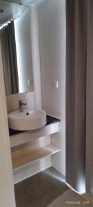 a bathroom with a sink and a mirror at Camping LES DUNES Mobil home 6 personnes in Torreilles