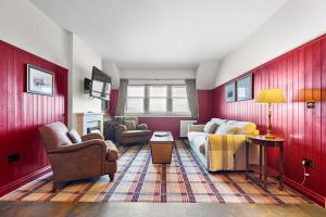 ein Wohnzimmer mit roten Wänden, einem Sofa und Stühlen in der Unterkunft Ugadale Cottages in Machrihanish