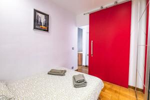 uma porta vermelha em um quarto branco com uma cama em Bright apartment at Les Invalides - 4 Guests em Paris