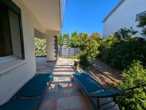 un patio con due sedie blu su una casa di F3 RDC jardin clôt et piscine privatifs, proche toutes activités ! ad Agde