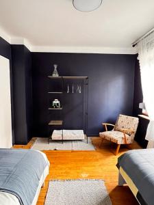 a bedroom with black walls and a chair and a bed at La Rose in Schiltigheim