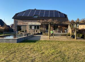 a house with solar panels on the roof at Het Kabinet in Munsterbilzen