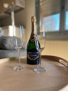 a bottle of champagne and two wine glasses on a table at Het Kabinet in Munsterbilzen