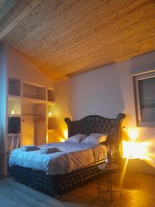 a bedroom with a bed with a wooden ceiling at O coeur du medoc in Saint-Julien-Beychevelle