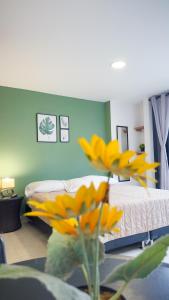 a room with a bed and a table with yellow flowers at Edificio Fenicia Loft Laureles in Medellín