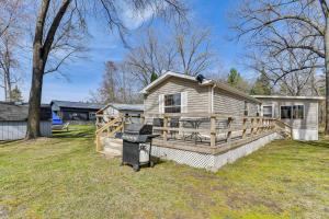 a house with a fence and a grill in a yard at Waterfront Home with Boat Slips in Northern Michigan in Gladwin