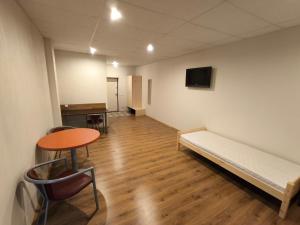 a room with a bed and a table and a tv at Vieta tavai atputai ar grilu in Liepāja