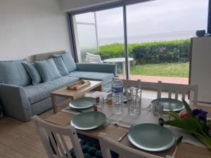a living room with a table and a couch at Le Colvert, appartement face mer in Le Crotoy