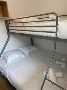 a bunk bed with two white pillows on it at Le Colvert, appartement face mer in Le Crotoy