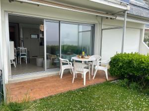 a patio with a table and chairs on a balcony at Le Colvert, appartement face mer in Le Crotoy