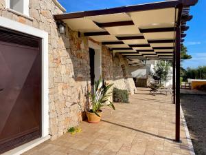 a patio with awning on the side of a building at TRULLO VISTA MARE - Mini piscina riscaldata con idromassaggio in Marina San Gregorio