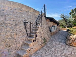 a stone wall with stairs next to a building at TRULLO VISTA MARE - Mini piscina riscaldata con idromassaggio in Marina San Gregorio +67 photos
