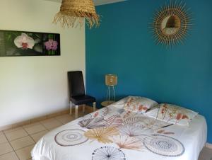 a bedroom with a bed with a blue wall at Le pigeonnier in Millau